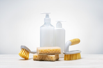 Fototapeta na wymiar Different liquid detergents and brushes, sponges for wet home cleaning. Eco biodegradable products.