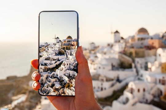 Making touristic photos via mobile phone. Smartphone using in Santorini island in Greece.