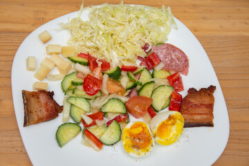 cold appetizer with boiled eggs, cucumber, salami, tomatoes and cheese