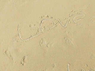 The word "Love" written in the sand