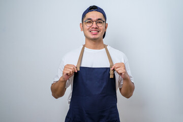 Naklejka premium Young barista man wearing apron standing proudly wearing apron