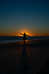 Fototapeta na wymiar person on the beach at sunset