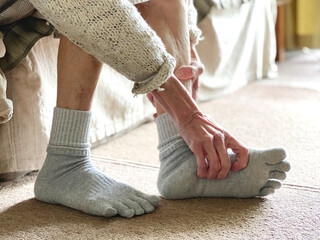足の裏をストレッチする高齢女性の手