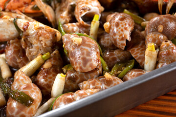 A closeup view of a baking pan of roasted periwinkles.