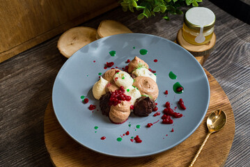 Three chocolate mousse with raspberry caviar. Dessert on a plate. Dark moody food photo.