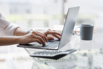 Close up of hand Asian businesswoman working on a laptop computer isolated over white background