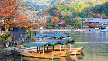 Fototapeta na wymiar Boat ride pier at Hozugawa River, boat for tourists to enjoy the autumn view along the bank of Hozu river, Arashiyama, Kyoto, Japan.