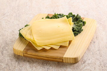 Sliced Gouda cheese over board