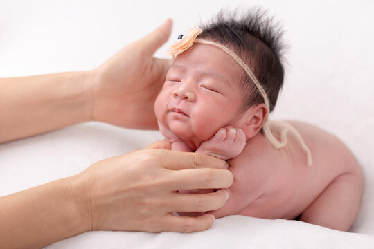 Behind the scenes of the shooting newborn baby. Photographer setting pose of newborn baby carefully.