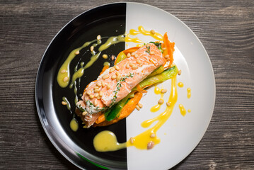 Salmon steak on a plate with Thai vegetables and sweet and sour mango sauce