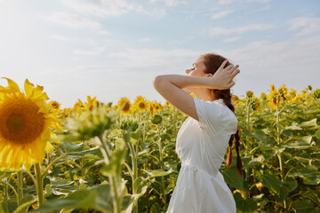 woman with pigtails in a white dress admires nature landscape