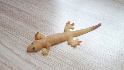 Fake rubber lizard toy on white wall.
Fake lizard which is made of clear silicone rubber.