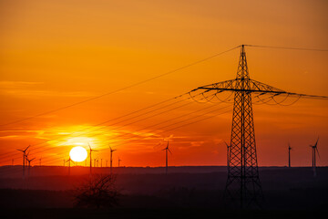 wind turbines and power lines at sunset