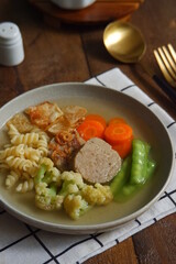 a plate of vegetables and meat soup 