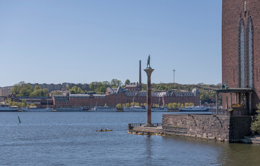 The parterre of the Town City Hall with canoers and the skyline of the district Södermalm a sunny...