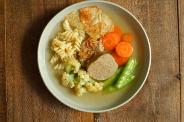 a plate of vegetables and meat soup 