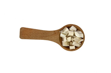 Pile of dried and sliced marshmallow root (Althaea officinalis) in a wooden spoon isolated on white background