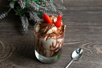 Tiramisu dessert with strawberries and chocolate sauce in a glass