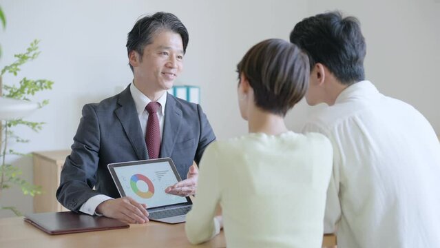 夫婦に営業するビジネスマン