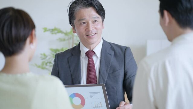 夫婦に営業するビジネスマン