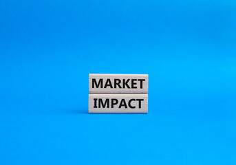 Market impact. Concept word Market impact on wooden cubes. Beautiful blue background. Business and Market impact concept. Copy space.