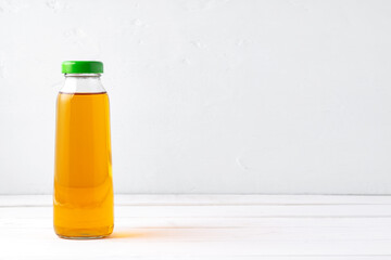 Small glass bottle of fresh juice on white background
