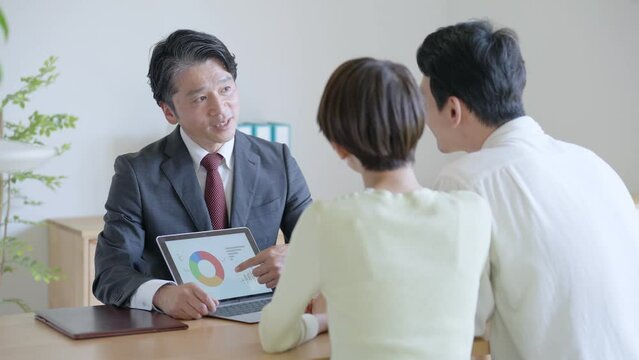 夫婦に営業するビジネスマン