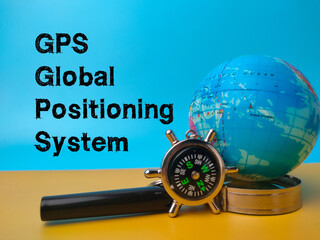 Compass,magnifying glass and earth globe with the word GPS (Global Positioning System)