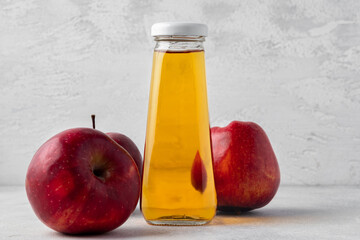 Apple juice in glass bottle with apples on table