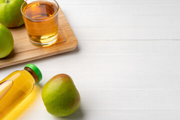 Fresh apple juice in bottles on gray background