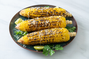 barbecue and grilled corn with cheese and lime