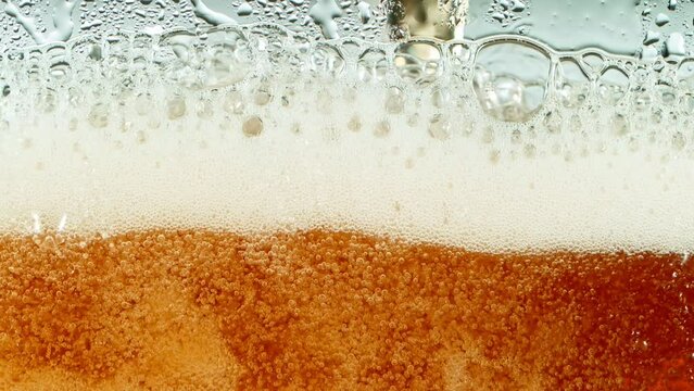 Super Slow Motion Detail Shot of Rippling Beer Bubbles and Foam