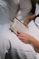 A woman reading a book in bed © Dawid