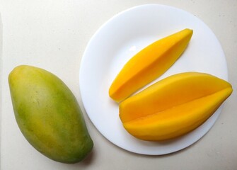 Sliced Golden orange ripe mango on a white plate. sour ann sweet ( kaew khamint mango.)