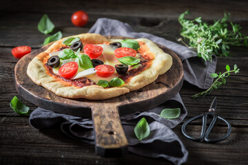 Tasty pizza with cheese, olives and herbs.