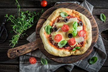 Rustic pizza with mozzarella, tomatoes and basil.