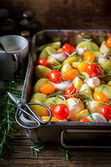 Homemade baked potatoes with garlic and cherry tomatoes.
