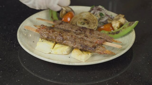 Turkish kebab service.
The chef pours capia peppers on the kebab.
