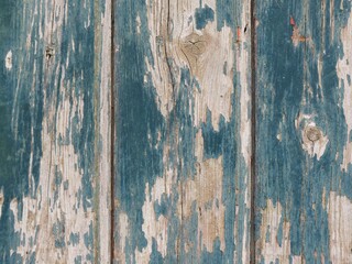 Détail d'une vieille porte de ferme en bois usée, avec peinture bleue écaillée