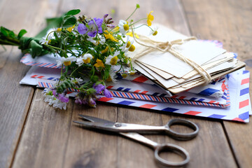old photographs, envelopes from letters, wild flowers bouquet on table, home archive documents,...