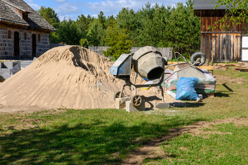 Concrete mixer. Construction site cement mixer machine, tools and sand