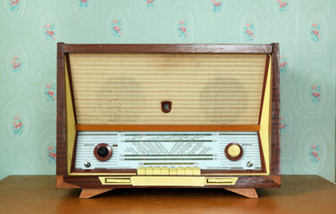 Vintage radiogram (radio) on the background of old wallpaper. Latvian Soviet vintage radiola...