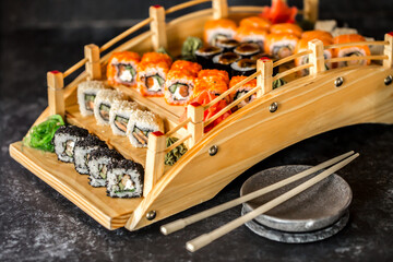 Sushi rolls Japanese delicacies. Japanese traditional rice and fish dishes. Beautiful serving food on a dark background with copy space. A set of delicious goodies.