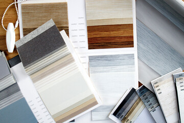 Samples of fabrics of different textures and colors in the form of a catalog for the selection of fabrics for fabric blinds. Samples of blinds day and night.