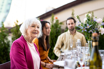 Family and friends celebrating at dinner on a rooftop terrace