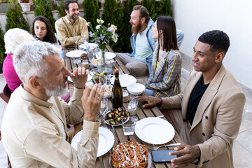 Family and friends celebrating at dinner on a rooftop terrace