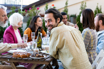 Family and friends celebrating at dinner on a rooftop terrace