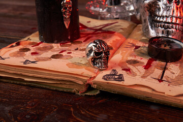Close-up metallic humans skull on the bible stained with blood. Wicca satanic antichrist ritual...