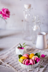 Good morning. Delicious macarons desserts are served on the table in the morning for breakfast. Beautiful light still life with a rose highlight. Baking for breakfast on a light table with copy space