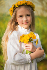 a beautiful blonde girl with long hair with a wreath of dandelions on her head stands in the sunset rays of the sun holding yellow flowers in her hands